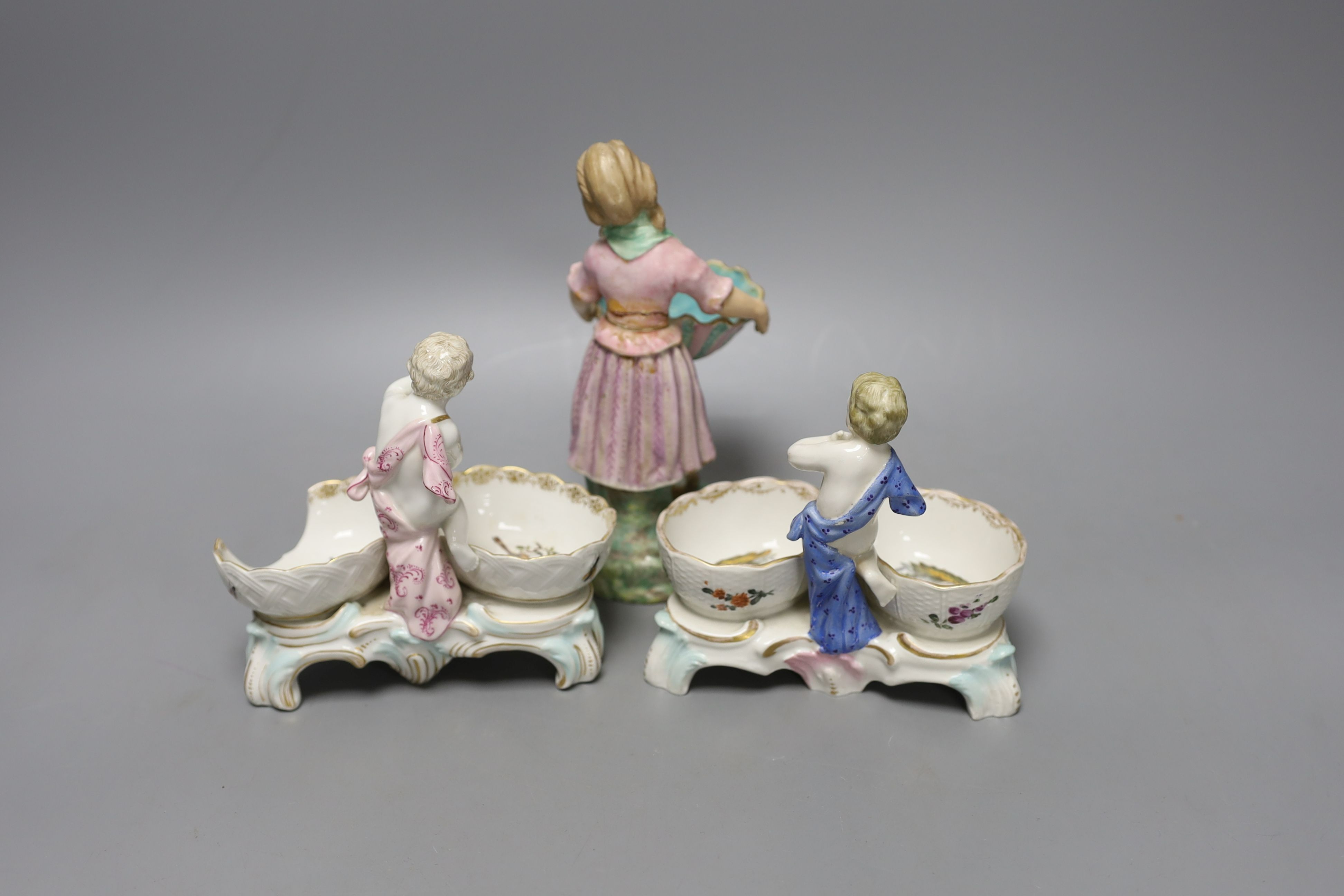 Two 19th century German porcelain putti salts and a Sampson Hancock, Derby figurine holding a shell (3) - tallest 17.5cm